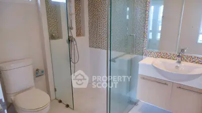 Modern bathroom with glass shower and mosaic tile accents