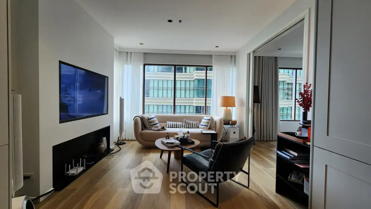 Modern living room with stylish furniture and large windows offering city views.