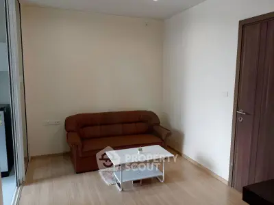 Cozy living room with brown sofa and white coffee table in modern apartment.