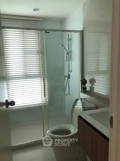 Modern bathroom with glass shower and sleek fixtures in a contemporary apartment.