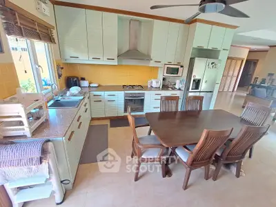 Spacious kitchen with modern appliances and dining area, featuring a gas stove and ample storage.