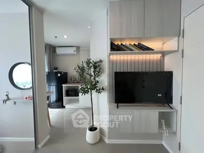Modern living room with sleek TV unit and stylish decor in contemporary apartment.