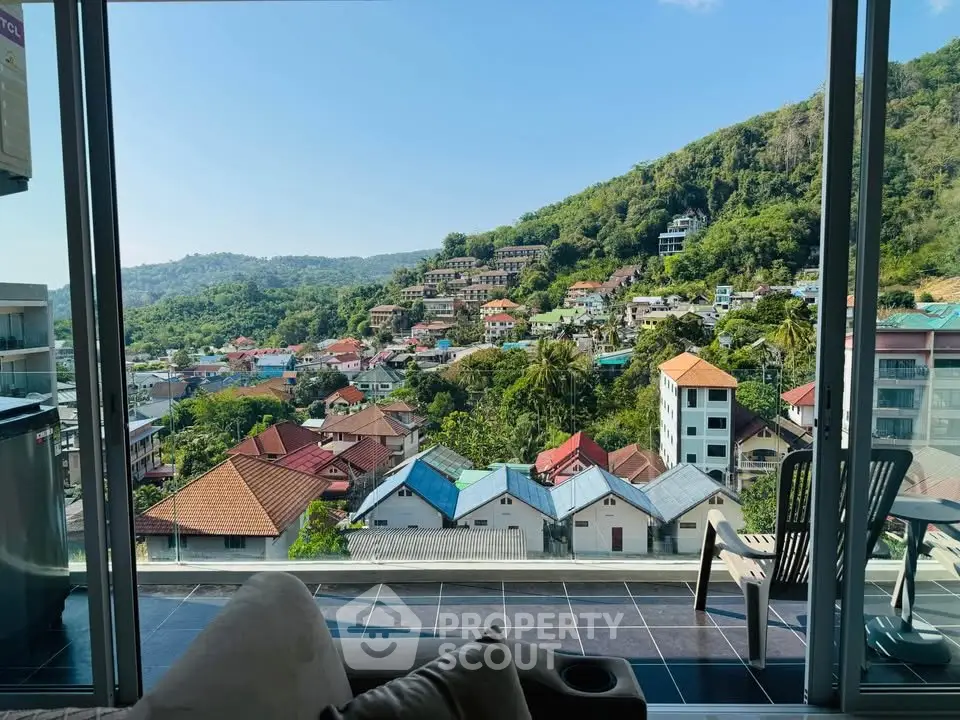 Stunning panoramic view from a modern balcony overlooking a picturesque hillside neighborhood.