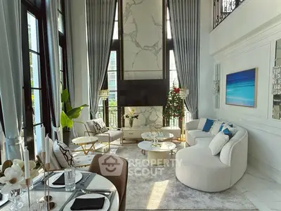 Luxurious high-ceiling living room with elegant decor and large windows.