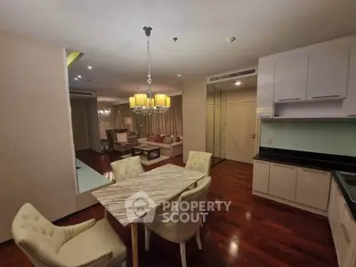 Elegant dining and living area with modern lighting and polished wooden floors.