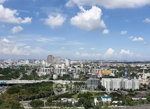 Stunning cityscape view with lush greenery and modern architecture under a clear blue sky.