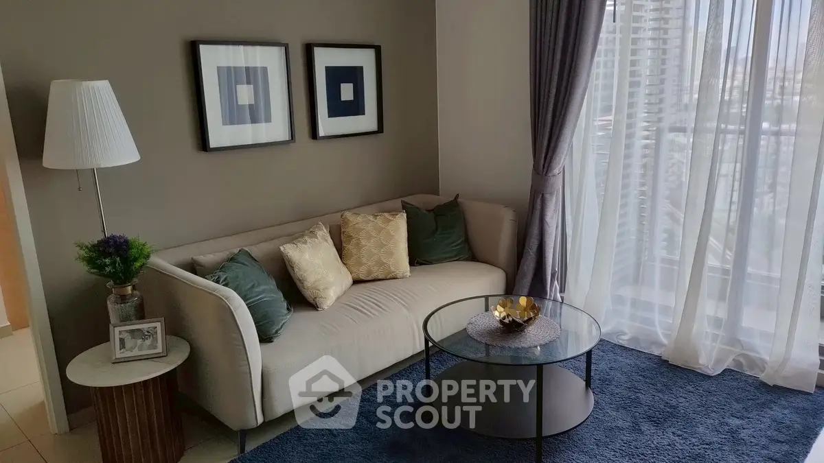 Stylish modern living room with elegant decor and large window view.