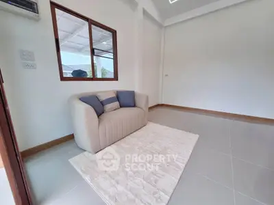 Cozy living room with modern sofa and natural light, perfect for relaxation.