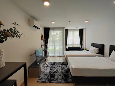 Spacious bedroom with modern decor and large windows for natural light.