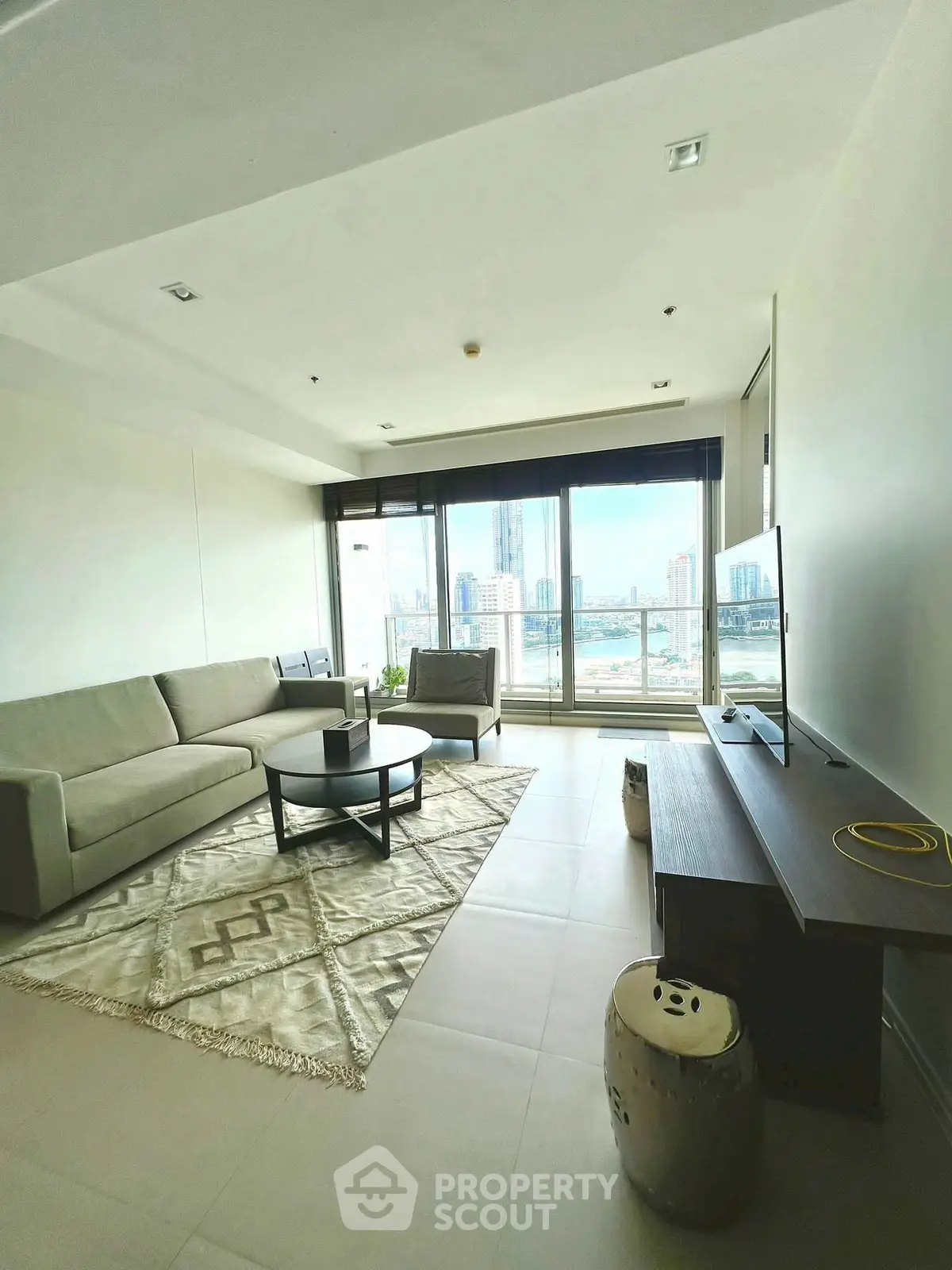 Spacious modern living room with panoramic city view and stylish decor.