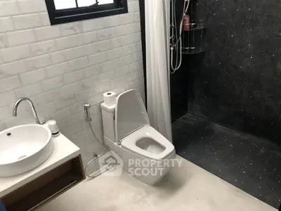 Modern bathroom with sleek design featuring a shower and stylish fixtures.