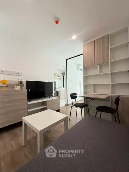 Modern living room with sleek furniture and built-in shelving in a cozy apartment.