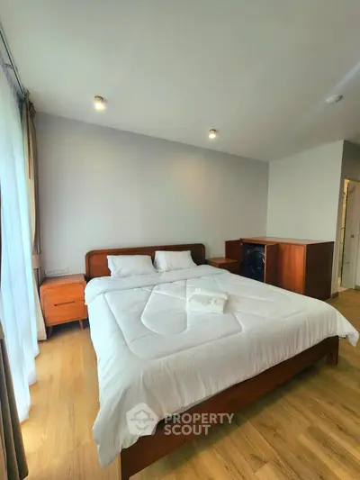 Spacious bedroom with modern wooden furniture and natural light