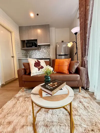 Chic modern living room with cozy sofa, stylish decor, and open kitchen layout in a contemporary apartment.