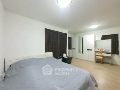 Spacious bedroom with modern furnishings and ample natural light.