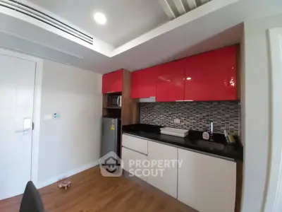 Modern kitchen with red cabinets and sleek design in a stylish apartment