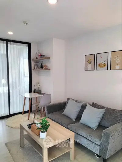 Modern living room with cozy gray sofa, stylish decor, and natural light for a welcoming ambiance.