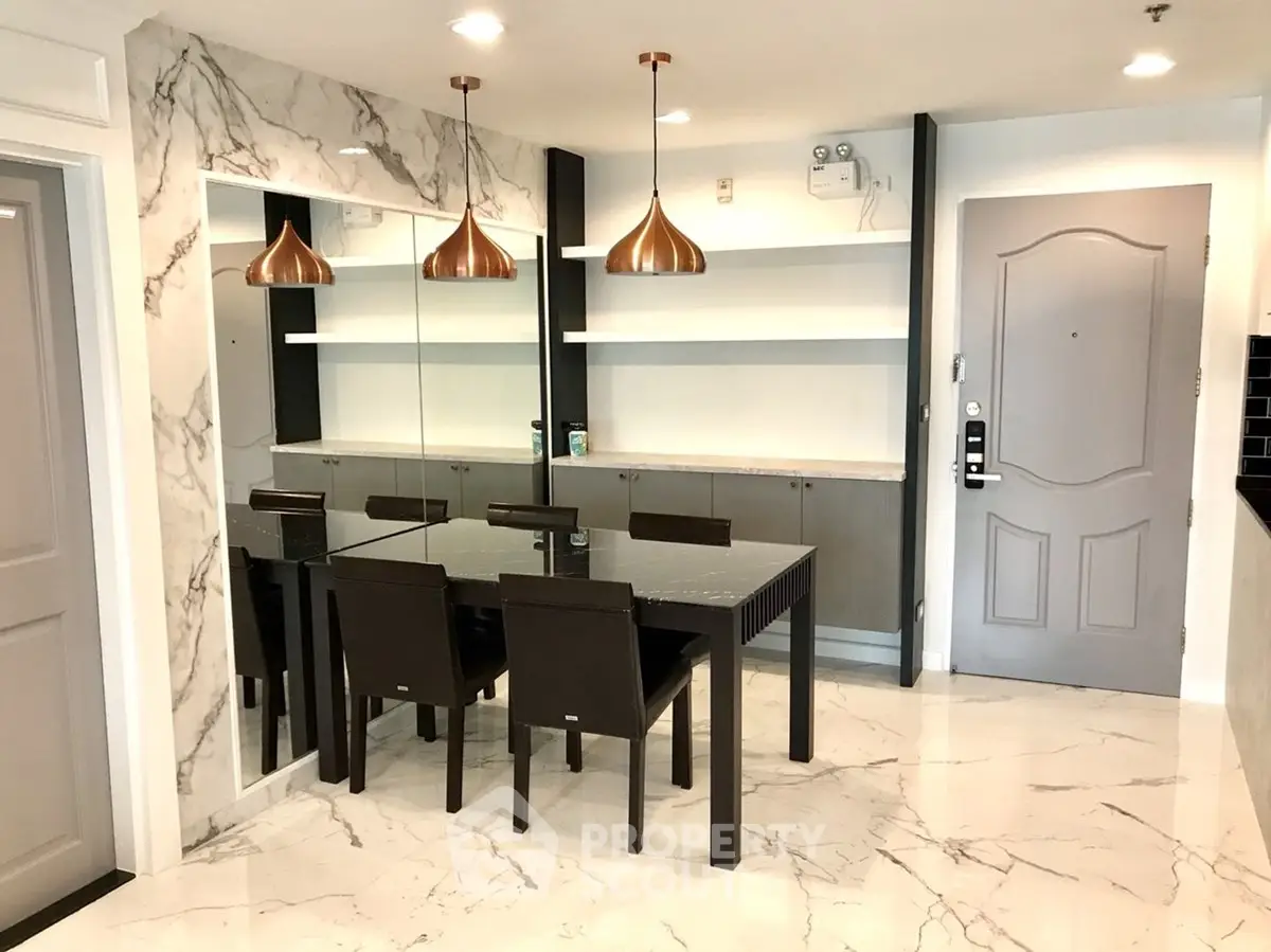 Modern dining area with marble flooring and stylish lighting in a contemporary apartment.