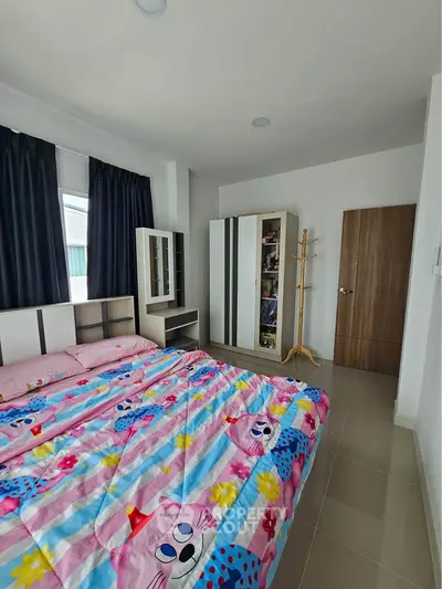 Charming bedroom with colorful bedding and modern wardrobe in a cozy apartment.