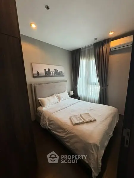 Cozy bedroom with modern decor and natural light, perfect for relaxation.