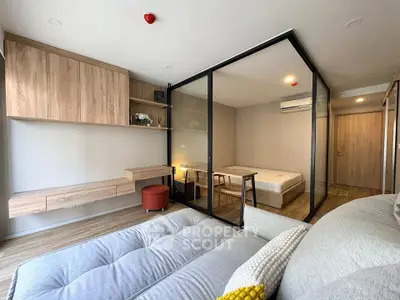 Modern studio apartment with glass partition, stylish furniture, and wooden accents for a cozy living space.