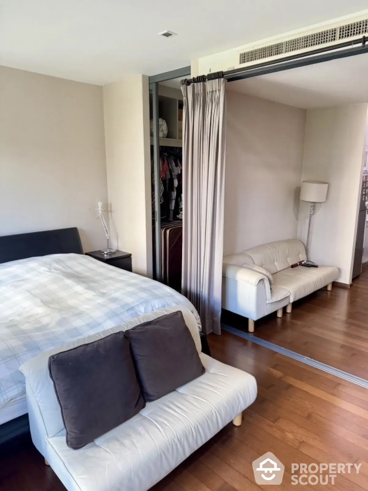 Spacious bedroom with modern decor and sliding closet doors in a stylish apartment.