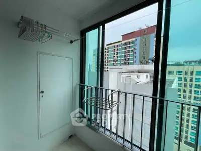 Modern apartment balcony with city view and laundry rack