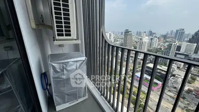 Stunning city view from high-rise balcony with modern railing and air conditioning unit.