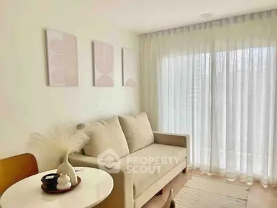 Cozy living room with natural light, beige sofa, and modern decor, perfect for relaxation and comfort.