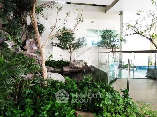Luxurious indoor garden with pool and lush greenery in modern building