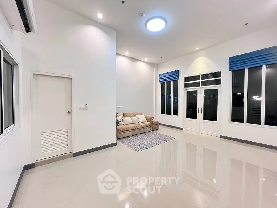 Spacious modern living room with sleek tile flooring and cozy sofa