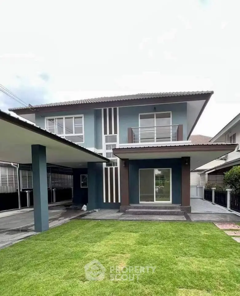 Modern two-story house with spacious lawn and sleek exterior design.