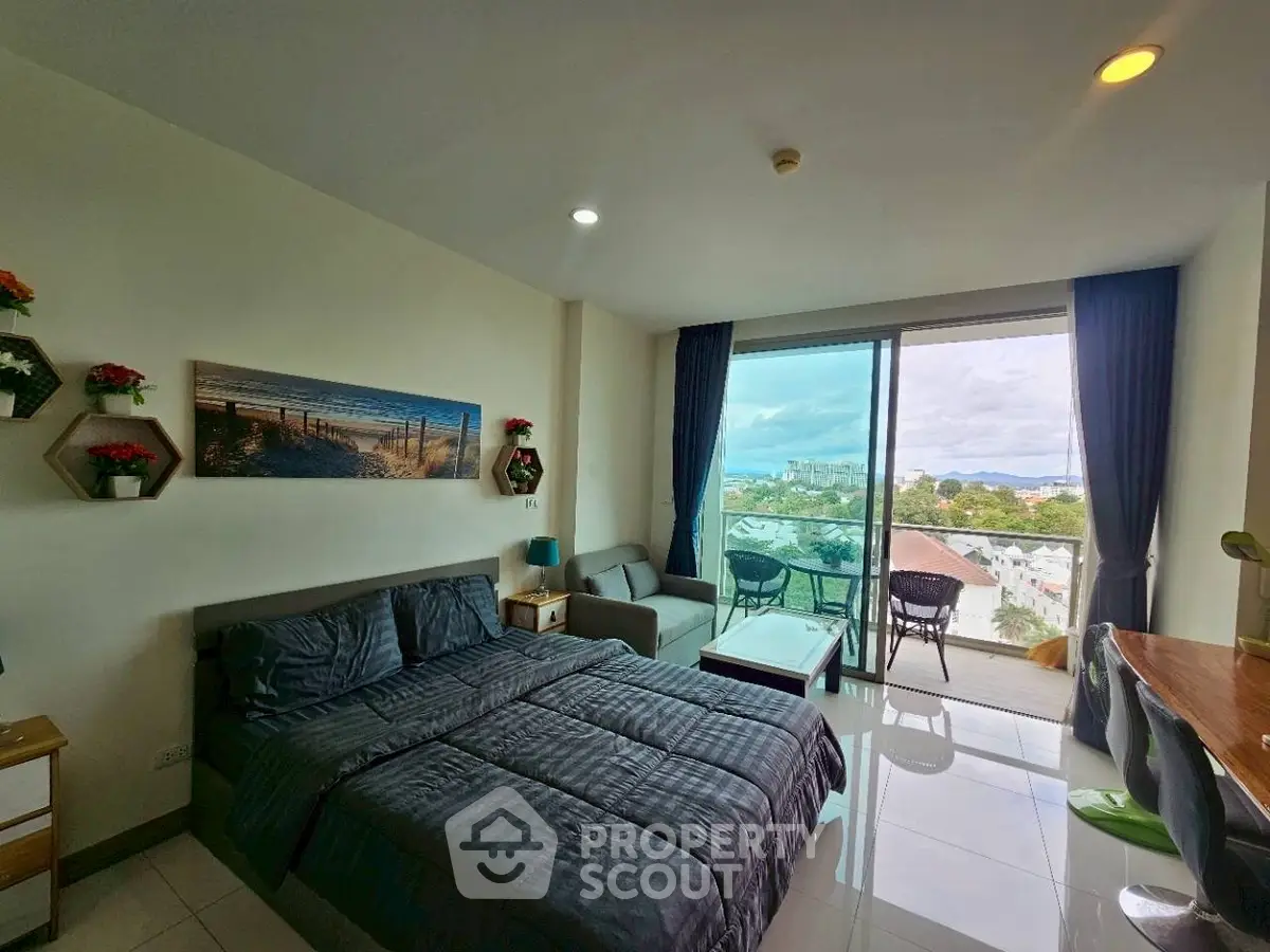 Modern bedroom with balcony and scenic view, featuring stylish decor and ample natural light.