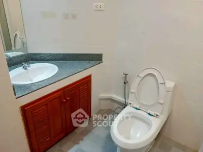 Modern bathroom with sleek sink and toilet in a minimalist design.