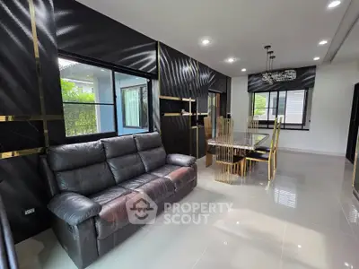 Luxurious modern living room with elegant dining area and sleek black leather sofa.