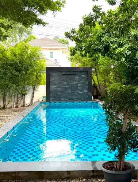 Luxurious outdoor pool surrounded by lush greenery, perfect for relaxation and entertainment.