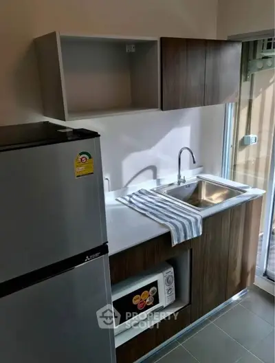 Modern kitchen with sleek cabinetry, stainless steel sink, and compact appliances for efficient living.