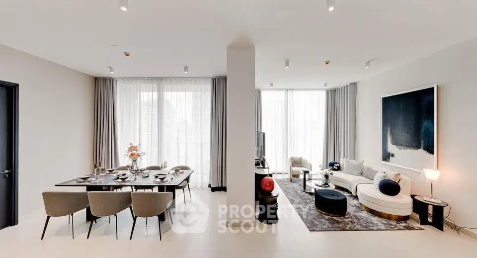 Luxurious open-plan living and dining area with modern decor and large windows.