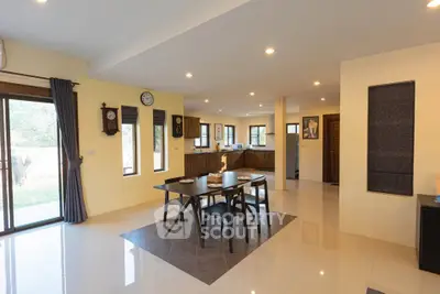 Spacious open-plan dining area with modern kitchen and natural light.