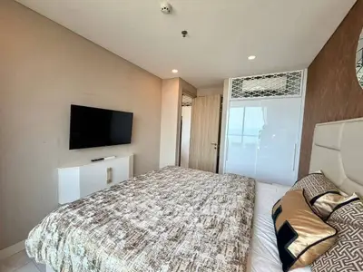 Modern bedroom with stylish decor and wall-mounted TV in a contemporary apartment.