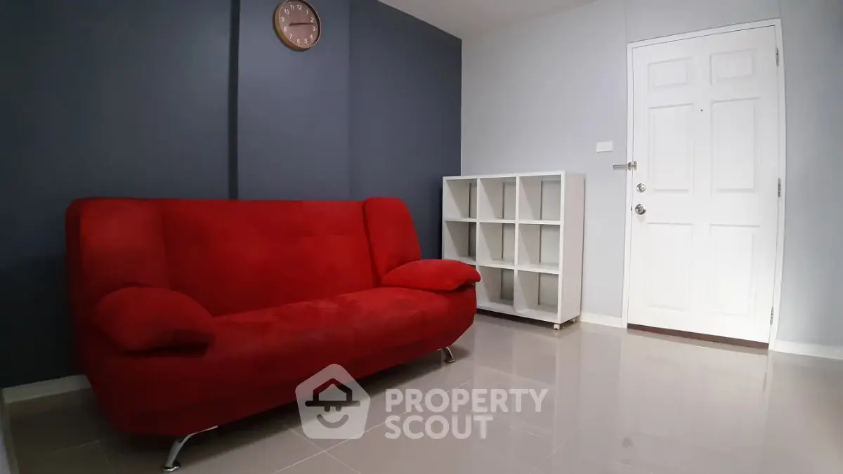Modern living room with red sofa and sleek white shelving unit