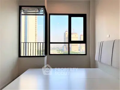 Modern bedroom with large windows offering a stunning city view, featuring sleek minimalist design.