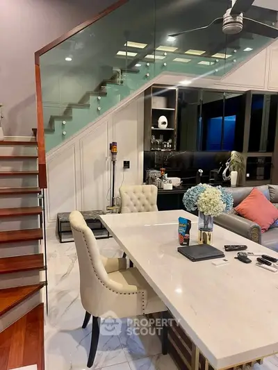 Luxurious modern living room with elegant staircase and stylish dining area