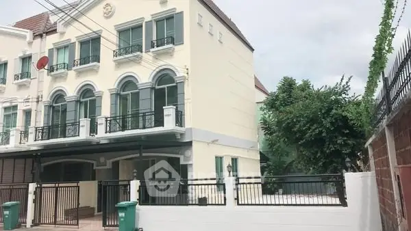 Elegant three-story townhouse with classic architecture and gated entrance in a serene neighborhood.