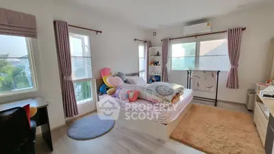 Cozy bedroom with plush decor and ample natural light