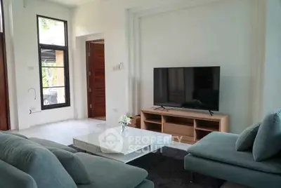 Modern living room with sleek furniture and large TV, perfect for relaxation and entertainment.