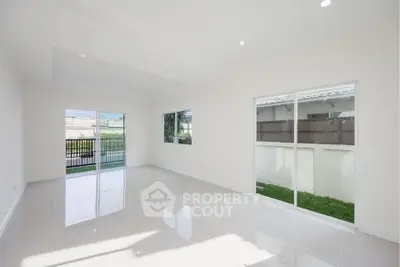 Spacious modern living room with large windows and garden view, perfect for natural light lovers.