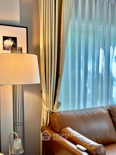 Elegant living room with leather sofa and floor lamp near large window with curtains.