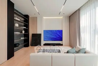 Modern living room with sleek design, large TV, and elegant shelving.