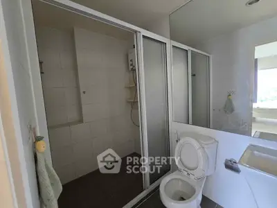 Spacious bathroom with shower and bathtub in modern apartment.